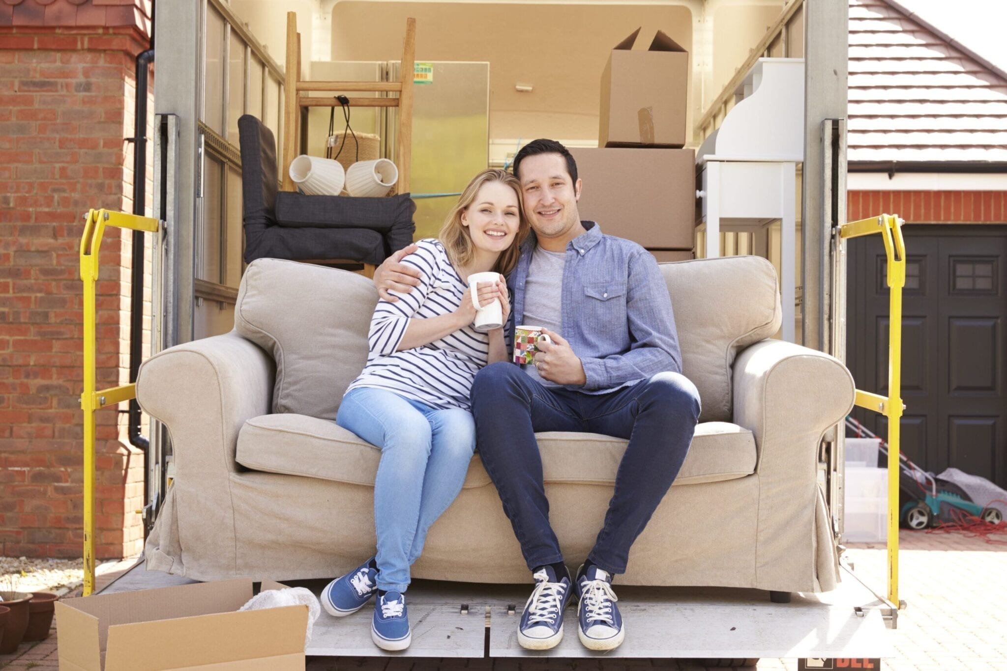 Calgary Moving Company couple with sofa on tail life of moving truck